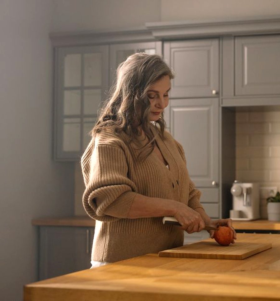 Une femme prépare son repas dans sa cuisine